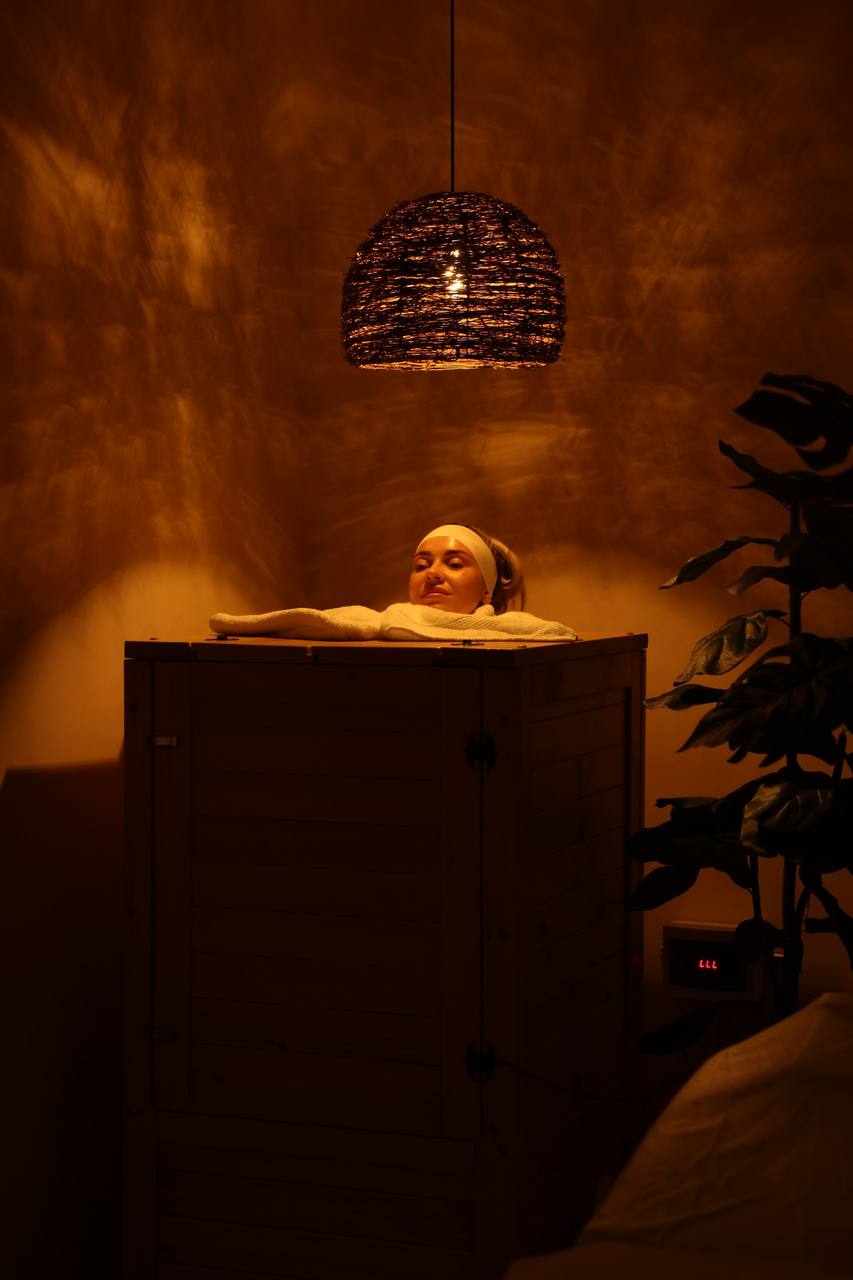 Client relaxing inside the herbal cedar steam sauna